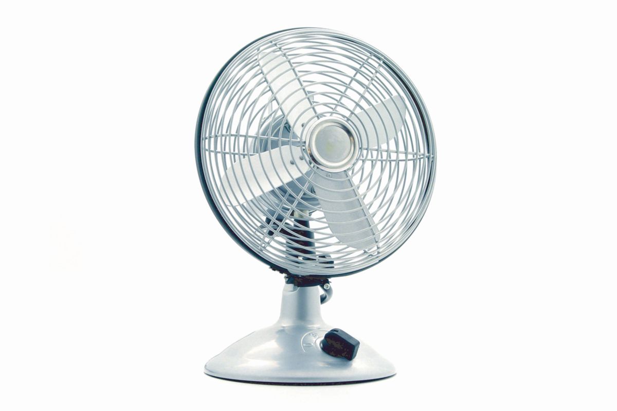 Ventilador de mesa metálico clásico sobre fondo blanco, listo para colocarle delante una sábana mojada y refrescar el aire.