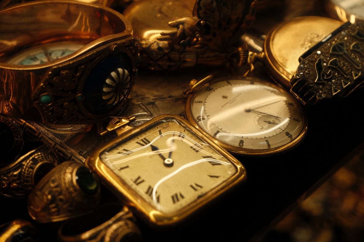 Colección de joyas y relojes de bolsillo antiguos de oro, con pulseras, anillos y piedras engastadas.