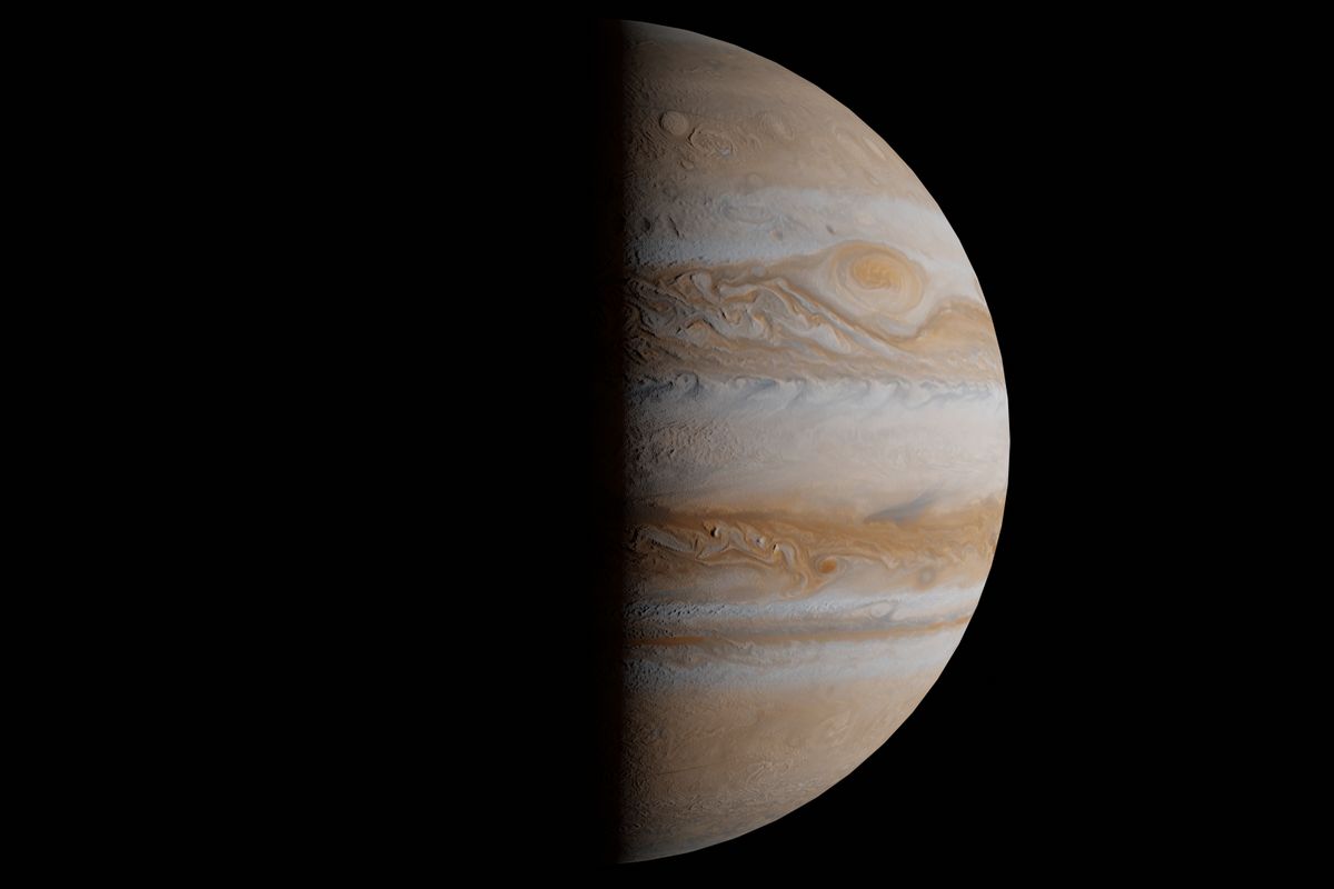 Fotografía de un gigante gaseoso de bandas anaranjadas y una gran tormenta ovalada, mitad iluminado sobre el fondo negro del espacio, similar al aspecto del planeta más joven del universo recién descubierto.