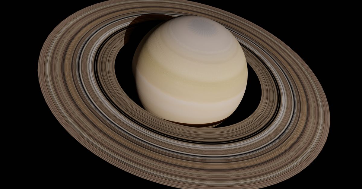 El planeta Saturno con sus anillos, visto de frente sobre fondo negro, con el patrón hexagonal de nubes asomando en el polo norte.